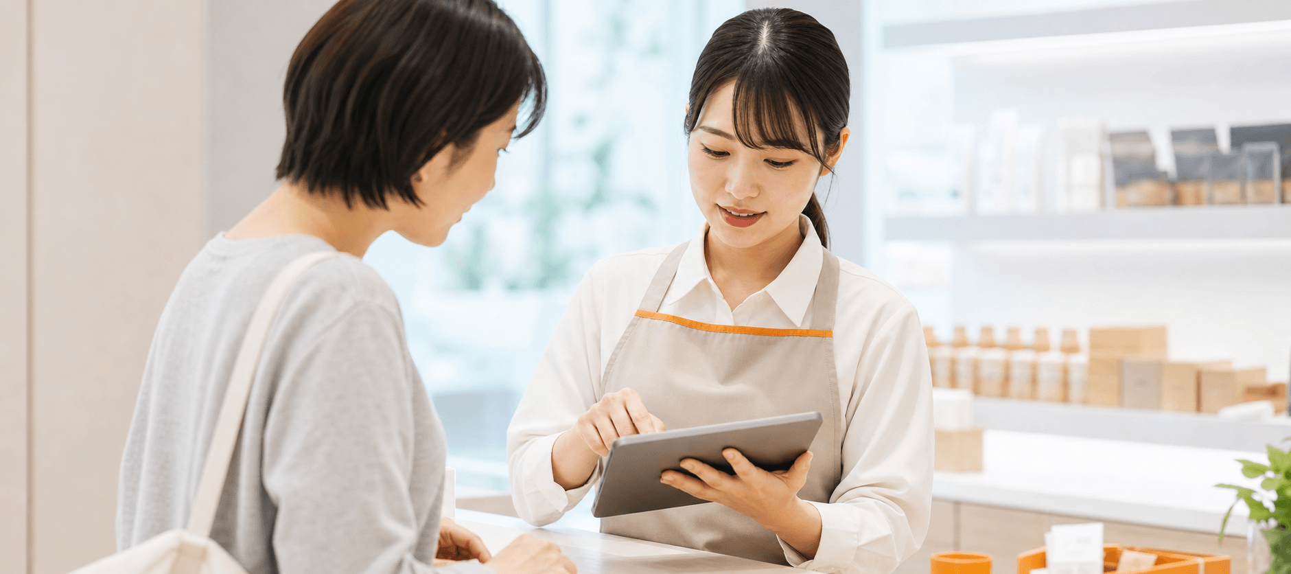 スタッフがタブレットの顧客情報を見ながら接客する様子