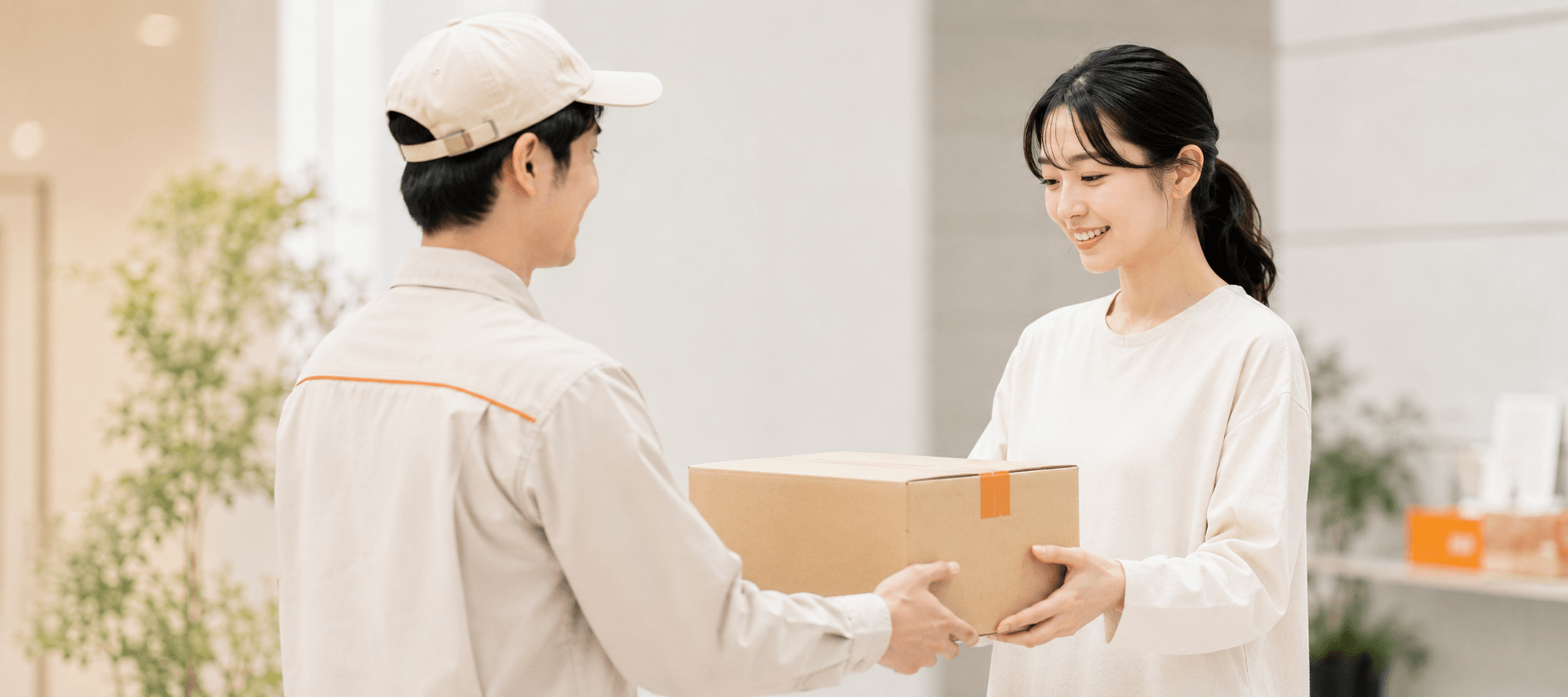 配送スタッフが自宅で顧客に荷物を手渡す様子